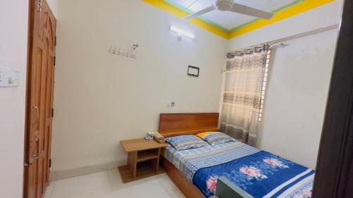 una piccola camera con letto e tavolo di Hotel Jom Jom International a Dhaka