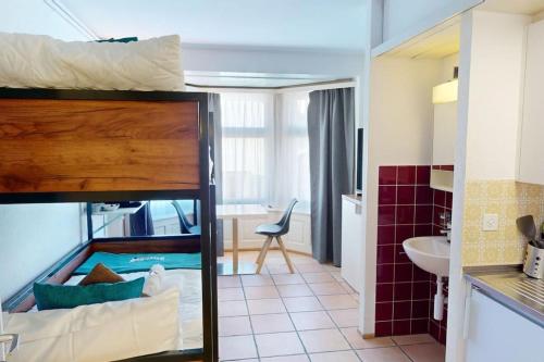 a bunk bed in a room with a bathroom at Solution-Grischun - Zentral - Etagenbett - Smart TV - Kaffe&Tee in Chur