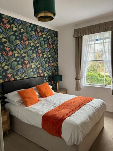 1 dormitorio con 1 cama con almohadas de color naranja en The Sandpiper Guest House, en Torquay