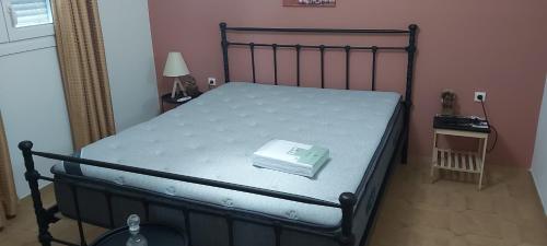 a bed with a book on it in a bedroom at Giannis Stella apartment in Mourteri