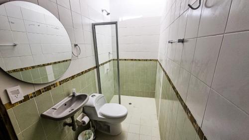 a bathroom with a sink and a toilet and a mirror at Guajira House in Ríohacha