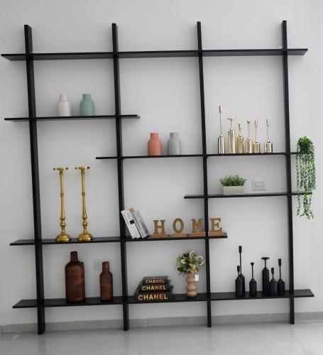 a black shelving unit with vases and other items at royal vila netivot in Netivot