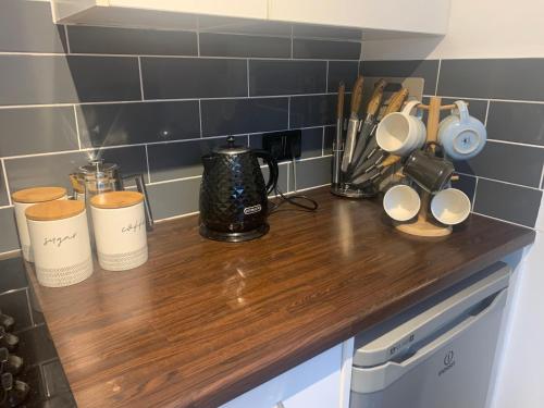 a kitchen counter with cups on a wooden counter top at Fabulous flat in the fantastic location of Gosforth in Gosforth
