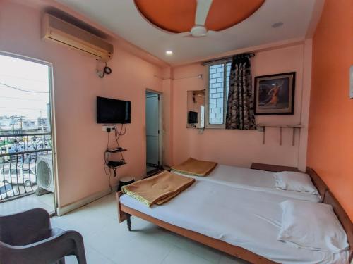 a bedroom with a bed and a large window at Hotel Annapurna in Bhuj