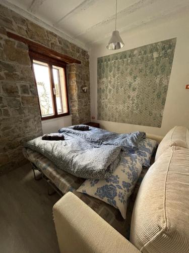 twee bedden in een kamer met een bakstenen muur bij Apartman Arioso in Piran