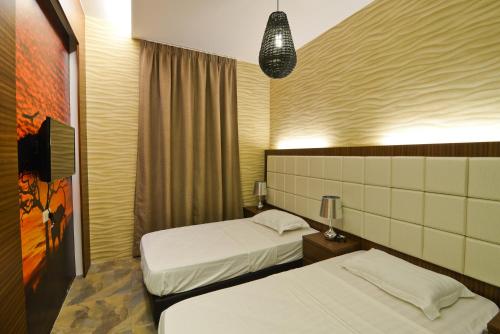 a hotel room with two beds and a tv at Parkview Homes in Ipoh