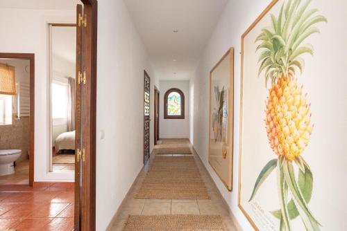 einen Flur mit einem Bild einer Ananas an der Wand in der Unterkunft Large villa with fantastic views in Benalmádena