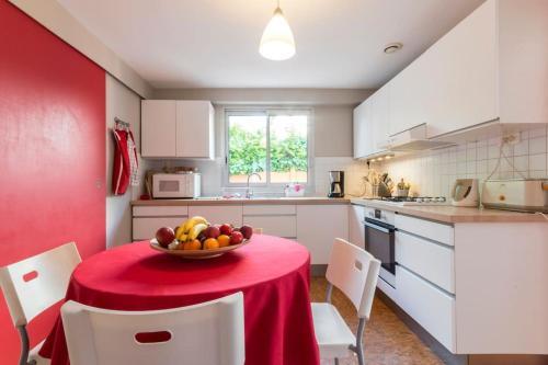 une cuisine avec une table avec un bol de fruits dessus dans l'établissement Rez de jardin 3 pièces 150m de la plage, à Pornichet