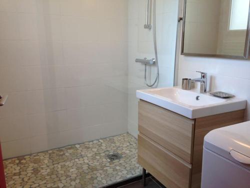 une salle de bain avec un lavabo et une douche dans l'établissement Rez de jardin 3 pièces 150m de la plage, à Pornichet