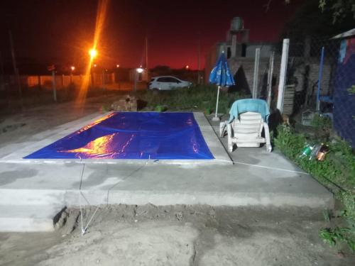 a swimming pool at night with a chair next to it at Cabaña La Solanita in Termas de Río Hondo