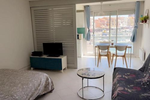 un salon avec un lit, une table et des chaises dans l'établissement Studio les 5M centre Port Cap d'Agde, au Cap d'Agde