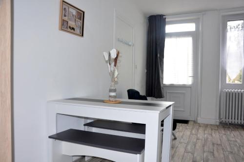 un escritorio blanco con un jarrón en una habitación en studio "Au Bord de l'Eau" 2, en Chambon-sur-Voueize