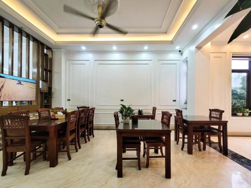ein Esszimmer mit Tischen und Stühlen sowie einem Deckenventilator in der Unterkunft TAM COC HARBOR VIEW HOTEL in Ninh Bình