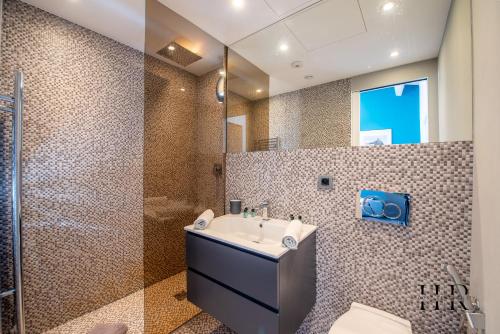 een badkamer met een wastafel en een douche bij Maison moderne avec piscine et tennis in Saint-Tropez