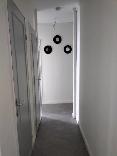 un couloir vide avec deux disques accrochés au mur dans l'établissement Joy's apartment, à Tours