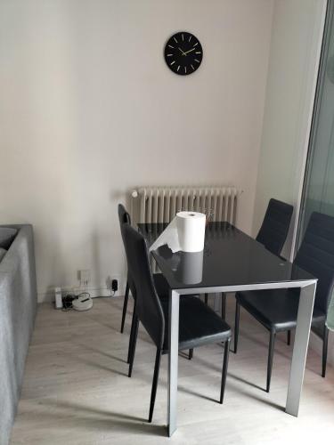 une table à manger avec des chaises et une horloge murale dans l'établissement Joy's apartment, à Tours