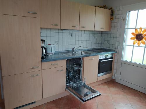 a kitchen with an appliance in the middle of a dishwasher at Ferienwohnung Lena in Stedesdorf bei Esens an der Nordseeküste in Ostfriesland in Stedesdorf