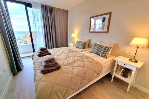 1 dormitorio con cama y ventana grande en Modern terrassed house close beach en Málaga