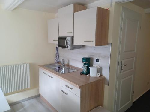 a small kitchen with white cabinets and a sink at Ferienwohnung Niederottendorf in Neustadt in Sachsen