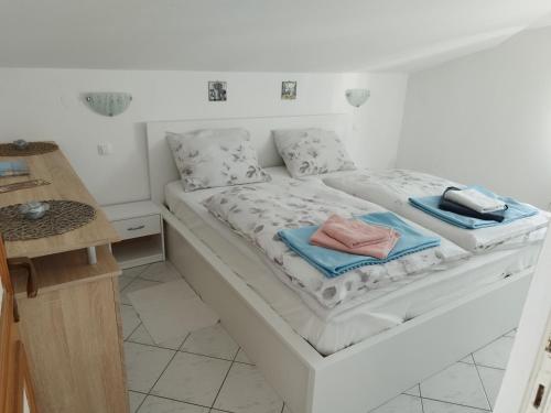 a white bed with towels on it in a room at CHERISH in Novalja