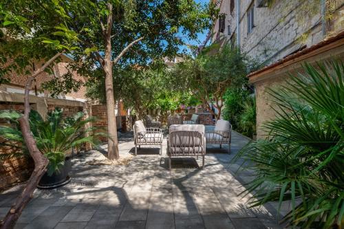 a patio with a table and chairs and trees at Azur Palace Luxury Rooms in Split