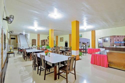 uma sala de jantar com mesas e cadeiras num restaurante em Malibou Hotel em Tebingtinggi