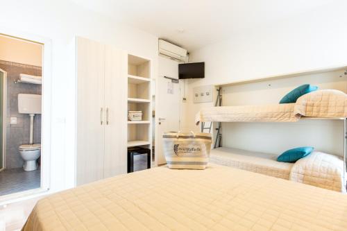 a bedroom with two bunk beds and a bathroom at Hotel Raffaello in Bellaria-Igea Marina