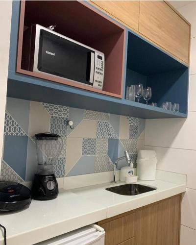 uma cozinha com um micro-ondas e um lavatório em APART 214 MARINAS em Tamandaré