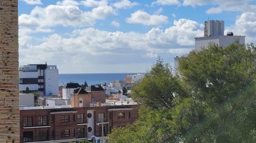 a view of a city with buildings and the ocean at Departamento moderno con cochera y parrilla, amplio y luminoso in Puerto Madryn