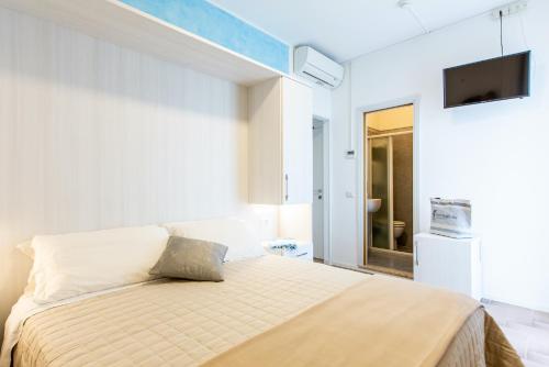 a bedroom with a bed and a tv on the wall at Hotel Raffaello in Bellaria-Igea Marina