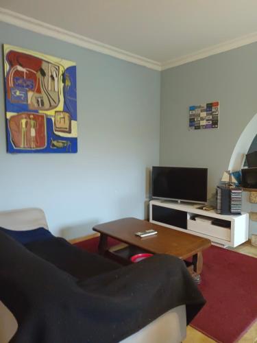 uma sala de estar com um sofá e uma mesa de centro em Location chez l habitant em Argentré-du-Plessis