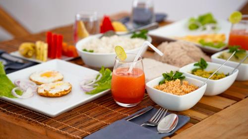 a table topped with plates of food and a drink at Moringa Mirissa in Mirissa