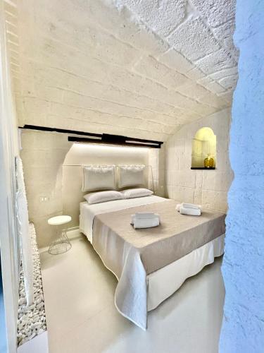 a bedroom with a large bed in a white room at MIA HOUSE APARTMENT in Monopoli