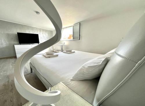 een slaapkamer met een groot wit bed en een ronde trap bij Life is Roma in Rome