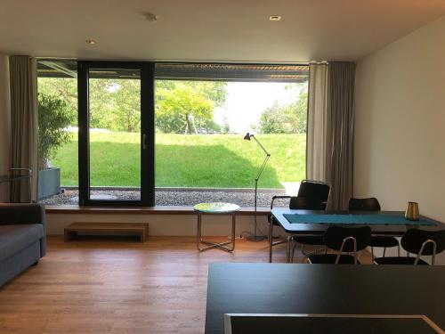 a living room with a table and a large window at Ferienwohnung Mainaublick in Konstanz