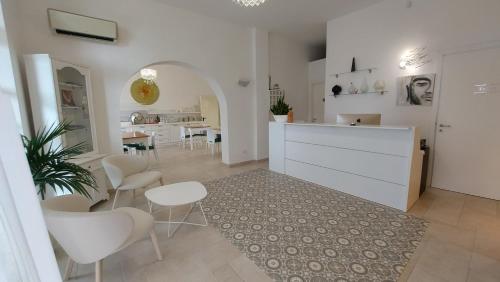uma cozinha e sala de jantar com cadeiras brancas e uma mesa em La Locanda della Castellana adults only em Peschici