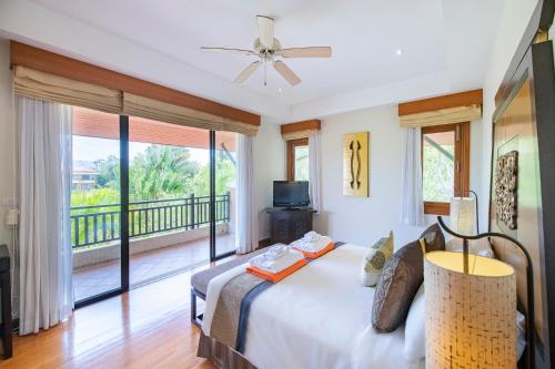 1 dormitorio con 1 cama y balcón en Laguna Pool Villa - Tranquil Views en Bang Tao Beach