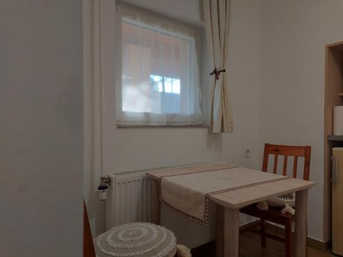 a small room with a table and a window at Potyka Apartman in Tiszafüred