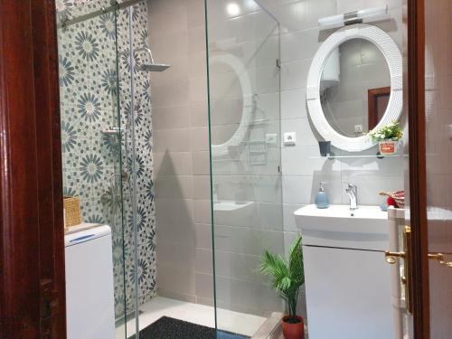 een badkamer met een douche, een wastafel en een spiegel bij Bel appartement moderne au cœur de guelize in Marrakesh
