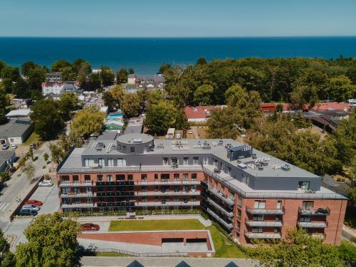 una vista aérea de un edificio con el océano en el fondo en Apartamenty Pilice, en Jastrzębia Góra