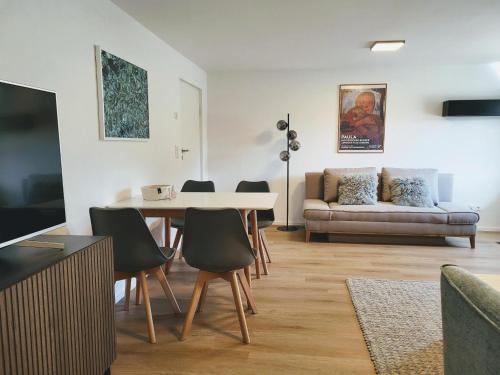 a living room with a table and chairs and a couch at ammersee apARTment Dießen in Dießen am Ammersee