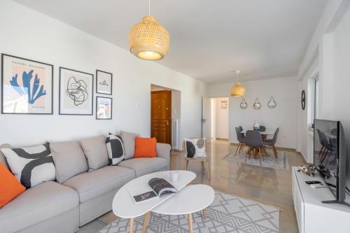 a living room with a couch and a tv at Panoramic Terrace with Sunset View - Greecing in Athens