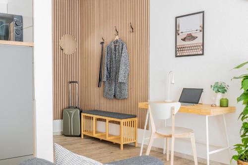 a room with a desk and a table with a suitcase at Apart4me Modern Apartment Geislingen zentral mit Parkplatz in Geislingen an der Steige