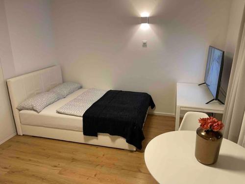 a bedroom with a bed and a table and a tv at Sweet Studio in the City Center Area in Ljubljana