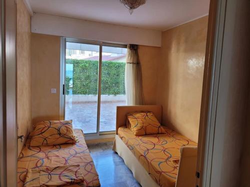 deux lits dans une chambre avec une fenêtre dans l'établissement FRONT DE MER Juan les Pins Cannes, à Antibes