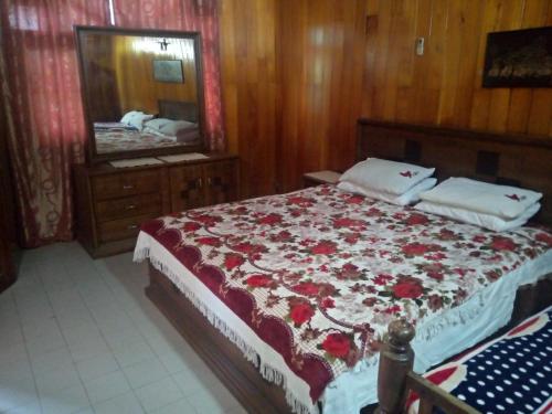 ein Schlafzimmer mit einem großen Bett mit roten Blumen darauf in der Unterkunft Maliga Inn in Gampola
