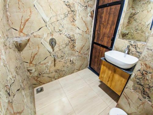 a bathroom with a sink and a stone wall at Hotel Arbuda Palace in Bhuj