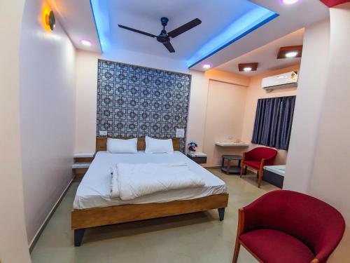 a bedroom with a bed and a ceiling fan at Hotel Arbuda Palace in Bhuj