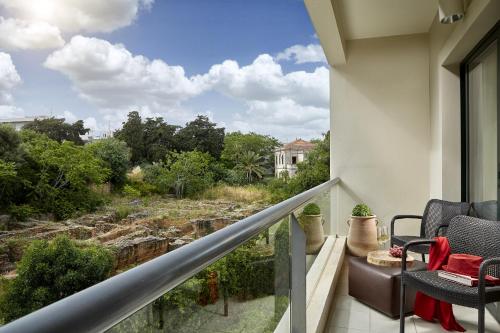 a balcony with chairs and a view of a river at Rodos Park in Rhodes Town