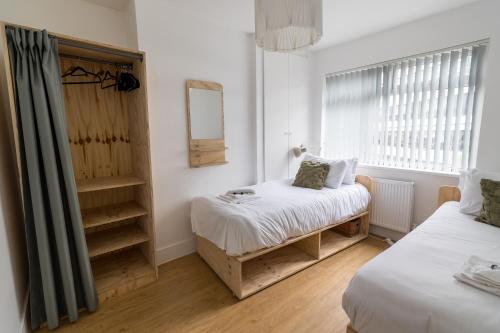 a small room with two beds and a mirror at Queens Croft Abode in Newport